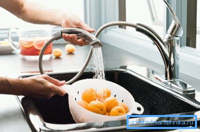 Mosás gyümölcsöt egy rugalmas kifolyó alatt Mosás gyümölcsöt egy rugalmas kifolyó alatt