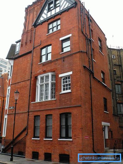 A fénykép - egy épület Londonban. Az újjáépítés során a csatornarendszert a homlokzatra helyezték. A fénykép - egy épület Londonban. Az újjáépítés során a csatornarendszert a homlokzatra helyezték.